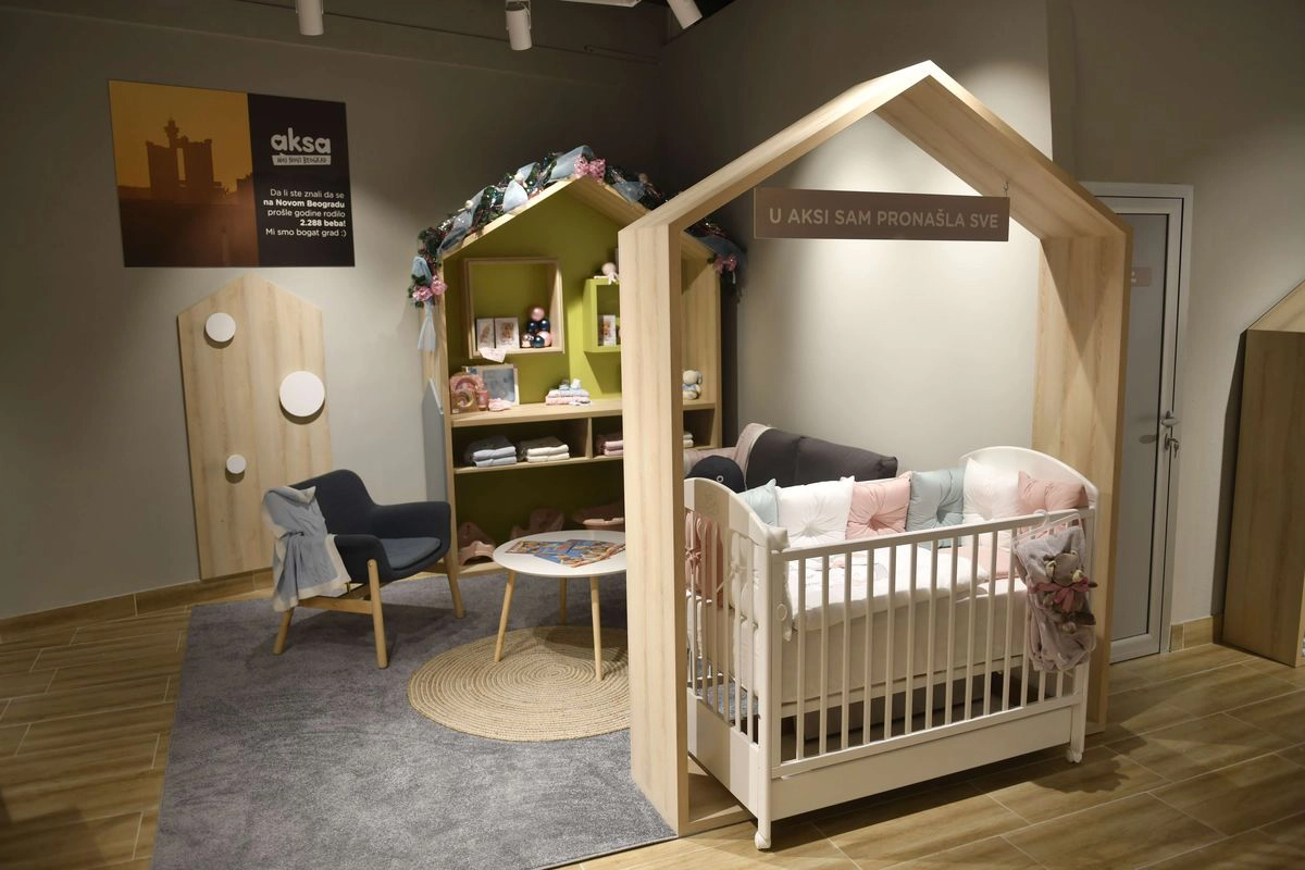Nursery furniture display with crib and house shaped decor