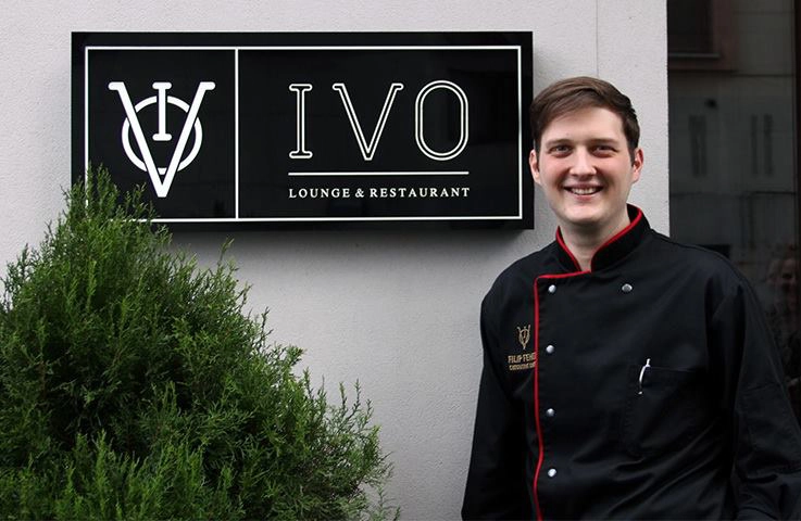 IVO restaurant chef standing in front of exterior signage